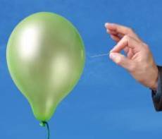 Needle about to pop a green balloon