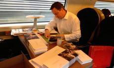 David Cameron signs Christmas cards on a train