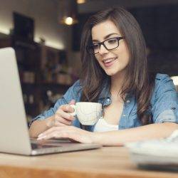 A young woman enjoys flexible working in a cafe