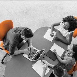 a group of people work together on laptops