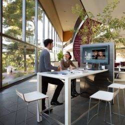 Colleagues talk in a bright and lively office design