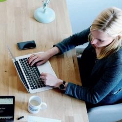 Woman working at desk illustrates challenges facing firms who want to offer flexible working to parents