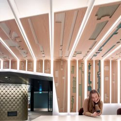 A worker checks her phone at KPMG Edinburgh, illustrating how important the design of workplace is