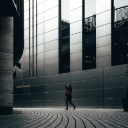 A person walks down an empty street in a central business district to reflect concerns about corporate real estate