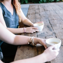 Two people talking over coffee about cancer support 