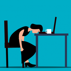 An exasperated woman at a desk rests her head on her laptop to show how women, including pregnant women,  can feel let down by outdated attitudes 